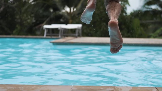 A guy with a beard dives into the pool. Lifestyle, attractive.