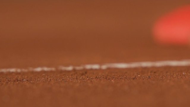 Slow motion of tennis ball hitting the gravel
