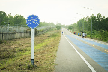 The bicycle path sign on the roadway. Selected focus.