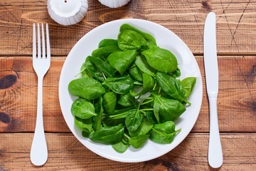 Step by step preparation of spinach salad with egg and cheese, step 2 - cleaning washing spinach for salad, top view, selective focus