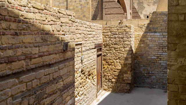 Old stone building with entrance door on narrow deadlock street of medieval town with sunlight