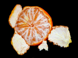 Start of cleaning ripe orange mandarin fruit  isolated on black  macro
