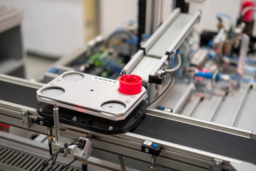 Close up of an automated car which is loaded at distribution station of smart factory prototype. Industry 4.0 smart factory concept; using artificial intelligence and Internet of Things in production.