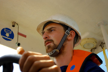 Seaman in safety helmet drive the rescue life boat.