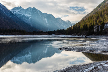 Predil lake in winter dress. Ice and reflections on the water. Tarvisio, Italy