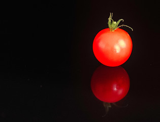Cherry tomatoe on black background . Food background.