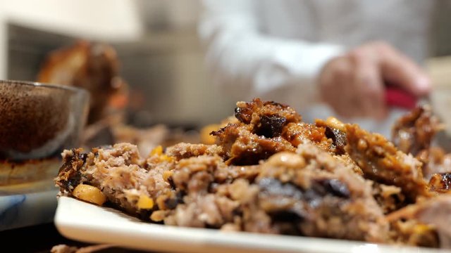 Turkey stuffing with gravy with family dad cutting in the backgroud.