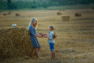 Mom and son close up in a field with mowed wheat.