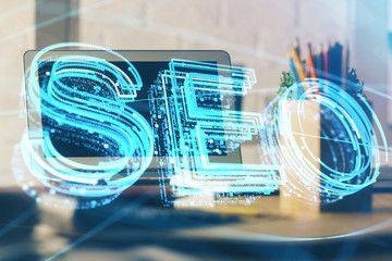 Multi exposure of table with computer and seo drawing hologram. Search optimization concept.