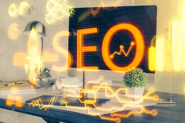 Multi exposure of table with computer and seo drawing hologram. Search optimization concept.