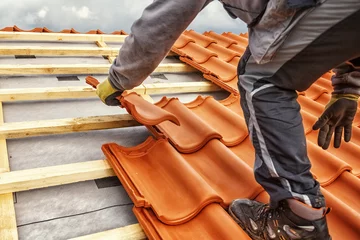 Deurstickers Roofer at work, installing clay roof tiles, Germany © Ingo Bartussek