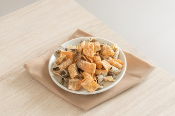 Crispy fried salmon skin on wooden table background.