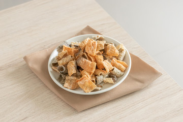 Crispy fried salmon skin on wooden table background.
