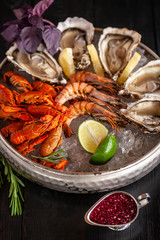 A large plate with seafood on ice. Crayfish, Shrimp and Oysters