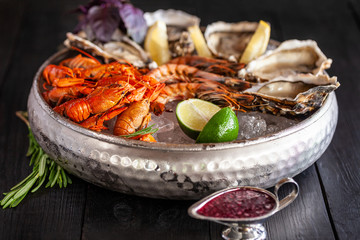 A large plate with seafood on ice. Crayfish, Shrimp and Oysters
