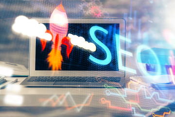 Multi exposure of table with computer and seo drawing hologram. Search optimization concept.