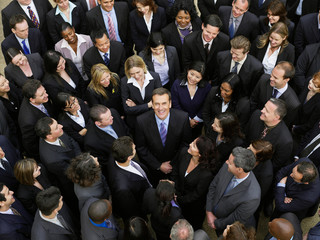 Overhead photo of large gathering of people in a large business crowd