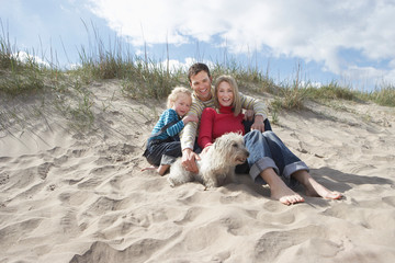 Parents with daughter (5-6) and dog on beach portrait