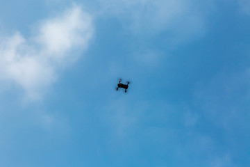 Fototapeta na wymiar quadrocopter in the blue sky with clouds
