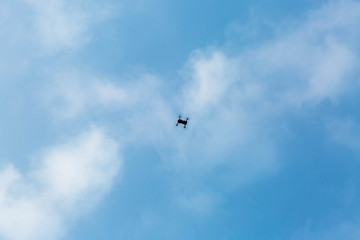 Fototapeta na wymiar quadrocopter in the blue sky with clouds