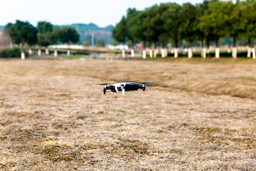 quadrocopter hovering above the ground in a park
