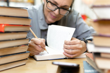 woman in the library in front of bookshelves. Concept of education