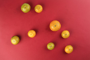small yellow green mandarin orange on red colour paper background copy space for text