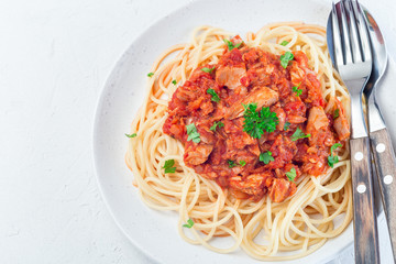 Spaghetti with tuna and tomato basil sauce garnished with parsley, horizontal, top view, copy space, closeup