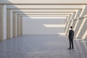 Businessman standing in minimalistic gallery interior
