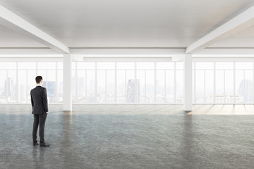 Fototapeta na wymiar Young businessman standing in minimalistic interior