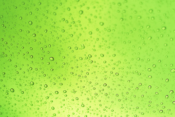 Water drop on green colour background with bubbles.