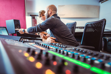 Sound engineer and singer or musician discussing the mix