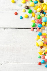  Colourful sweets on white wooden table with copyspace. Top view
