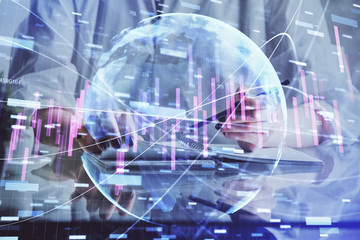 Financial forex graph drawn over hands taking notes background. Concept of research. Double exposure