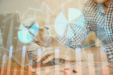 Multi exposure of forex graph with man working on computer on background. Concept of market analysis.