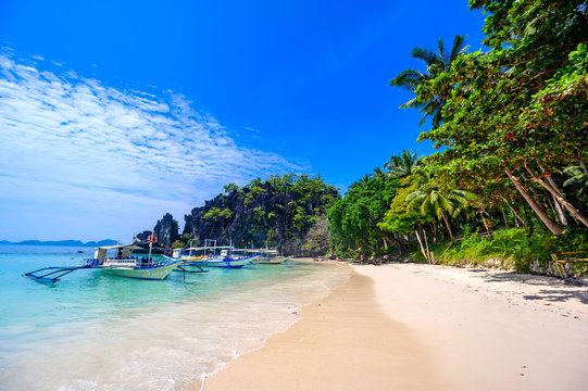 Tropical Papaya beach at paradise coast, El Nido, Palawan, Philippines. Tour A Route. Coral reef and sharp limestone cliffs.