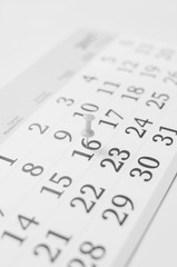 Black and white monthly calendar on table with office supplies