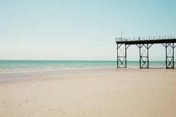 Pier stands on beach at low tide
