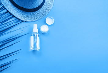 Generic beauty products on classic blue background. Summer travel kit or sun protection concept.