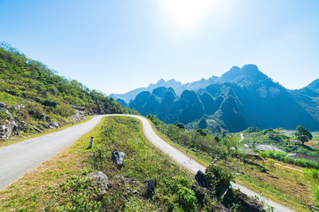 Fototapeta premium Ha Giang karst geopark mountain landscape in North Vietnam. Winding road in stunning scenery. Ha Giang motorbike loop, famous travel destination bikers easy riders.