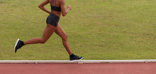 Female athlete running on stadium track, dynamic run of sprinter in a stadium