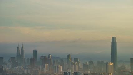 Kuala Lumpur morning mist with yellow sunlight.