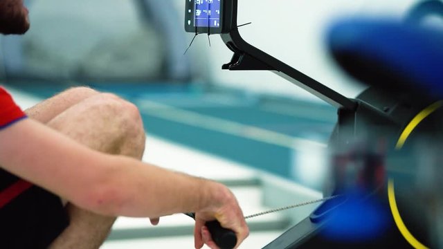 Professional athlete training on magnetic rowing machine. Man rower workout oaring in gym. powerful row training 