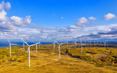 The Windmills park of Paldiski. Wind turbine farm near Baltic sea. Autumn landscape with windmills, orange forest and blue sky. Pakri peninsula, Estonia, Europe © Della_Liner
