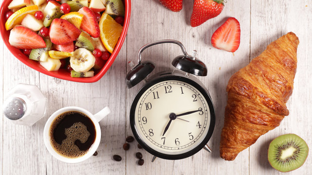 alarm clock with fruit, coffee and croissant