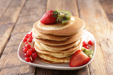 stack of pancakes with berries fruits and honey