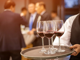 waiter serving glass of red wine