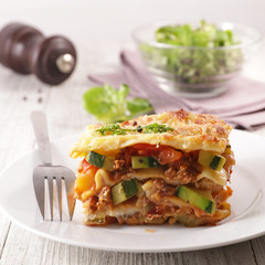 plate of lasagna with minced beef, tomato sauce and vegetable