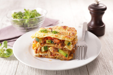 plate of lasagna with minced beef, tomato sauce and vegetable