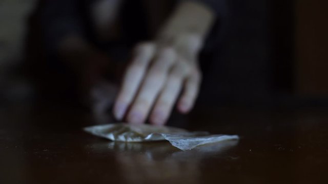 Female addict pushing a syringe and bag of powder, addiction treatment concept